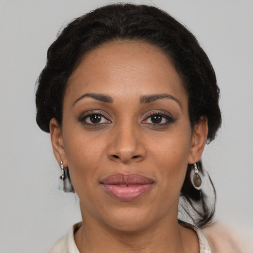 Joyful black adult female with medium  brown hair and brown eyes