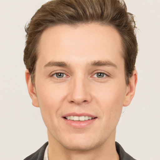 Joyful white young-adult male with short  brown hair and grey eyes