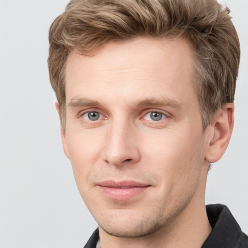 Joyful white young-adult male with short  brown hair and grey eyes