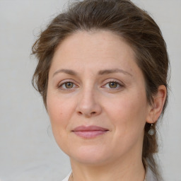 Joyful white adult female with medium  brown hair and grey eyes