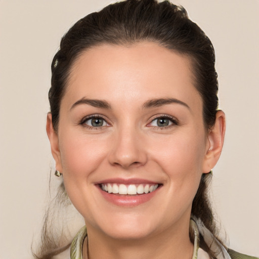 Joyful white young-adult female with medium  brown hair and green eyes