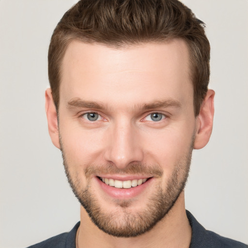 Joyful white young-adult male with short  brown hair and grey eyes