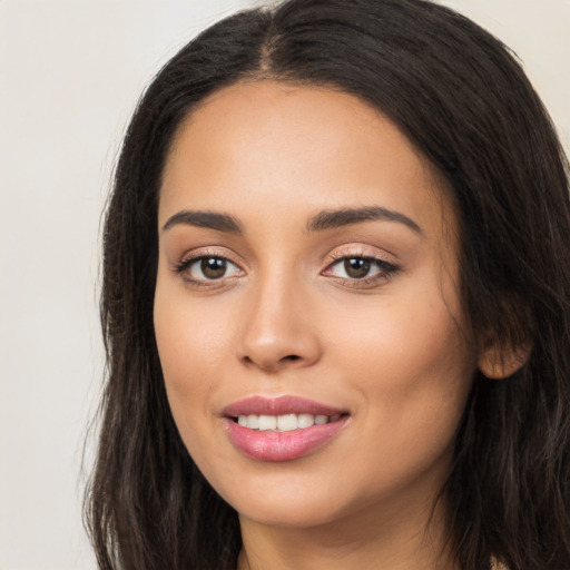 Joyful latino young-adult female with long  black hair and brown eyes