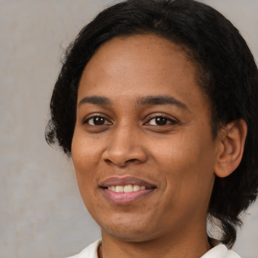 Joyful latino adult female with medium  black hair and brown eyes