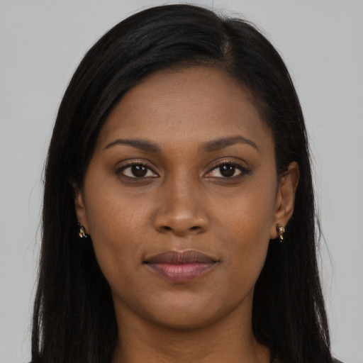 Joyful black young-adult female with long  brown hair and brown eyes