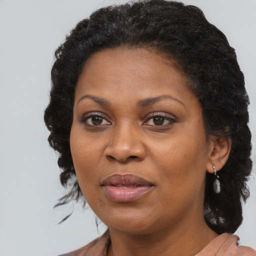 Joyful black adult female with long  brown hair and brown eyes