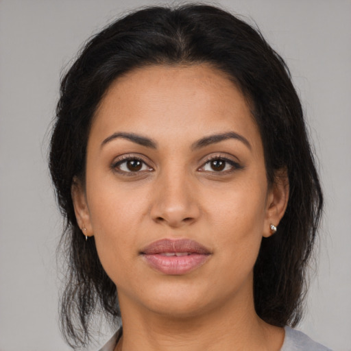 Joyful latino young-adult female with medium  brown hair and brown eyes