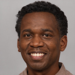 Joyful black adult male with short  brown hair and brown eyes