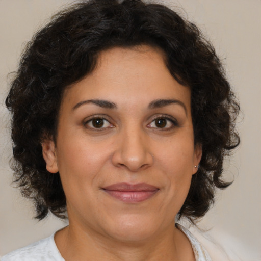 Joyful latino adult female with medium  brown hair and brown eyes