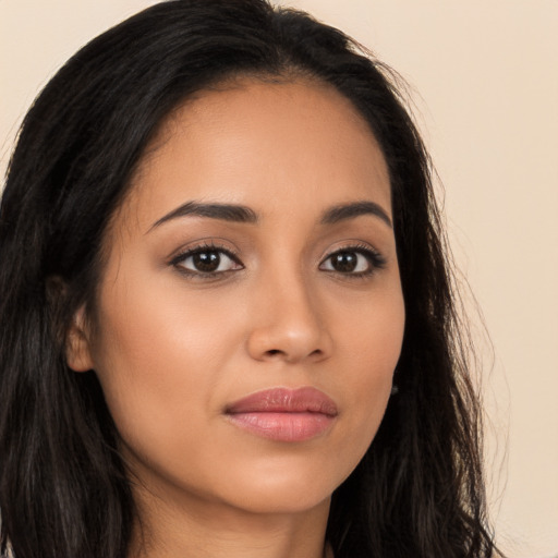 Joyful latino young-adult female with long  brown hair and brown eyes