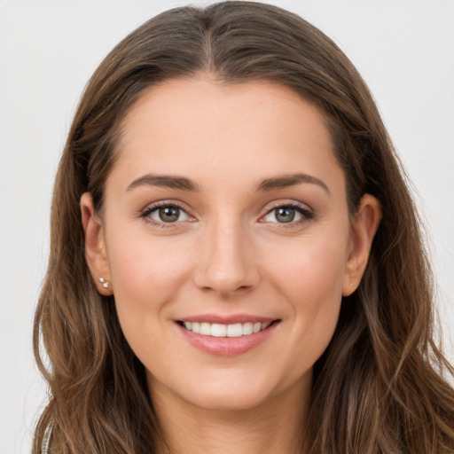 Joyful white young-adult female with long  brown hair and green eyes