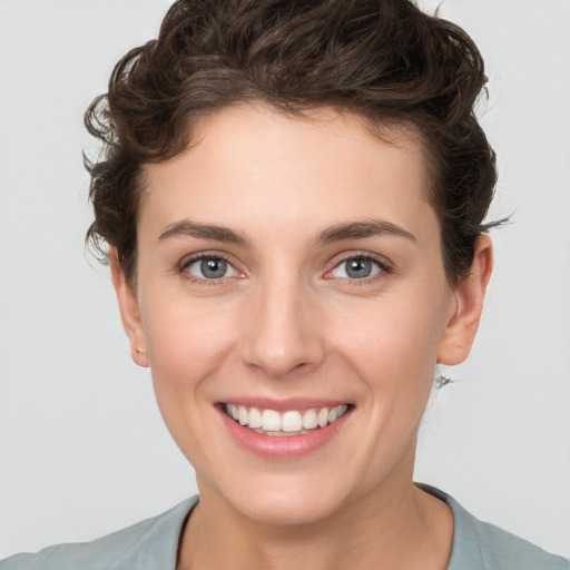 Joyful white young-adult female with short  brown hair and grey eyes