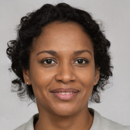 Joyful black adult female with medium  brown hair and brown eyes