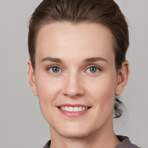 Joyful white young-adult female with short  brown hair and grey eyes