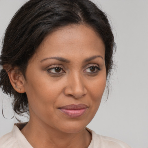 Joyful latino adult female with medium  brown hair and brown eyes