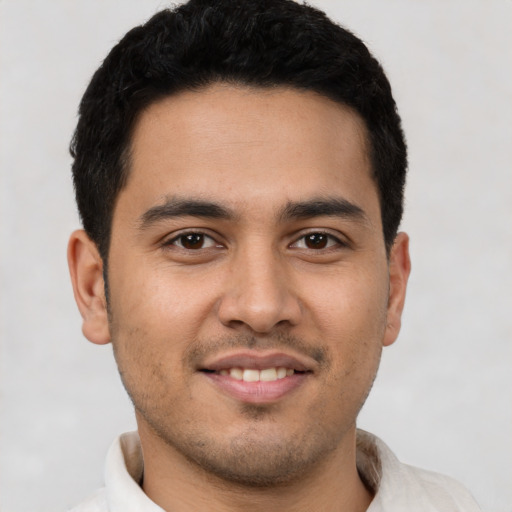 Joyful latino young-adult male with short  black hair and brown eyes