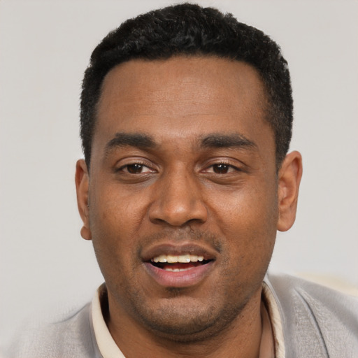 Joyful black young-adult male with short  black hair and brown eyes