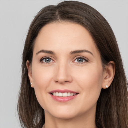 Joyful white young-adult female with long  brown hair and brown eyes