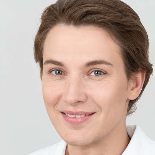 Joyful white young-adult female with short  brown hair and grey eyes