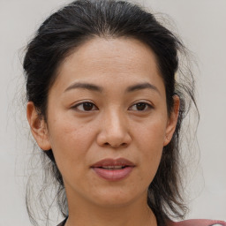 Joyful asian adult female with medium  brown hair and brown eyes