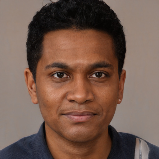 Joyful black young-adult male with short  black hair and brown eyes