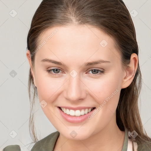 Joyful white young-adult female with medium  brown hair and grey eyes