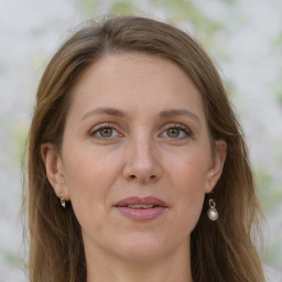 Joyful white adult female with long  brown hair and grey eyes