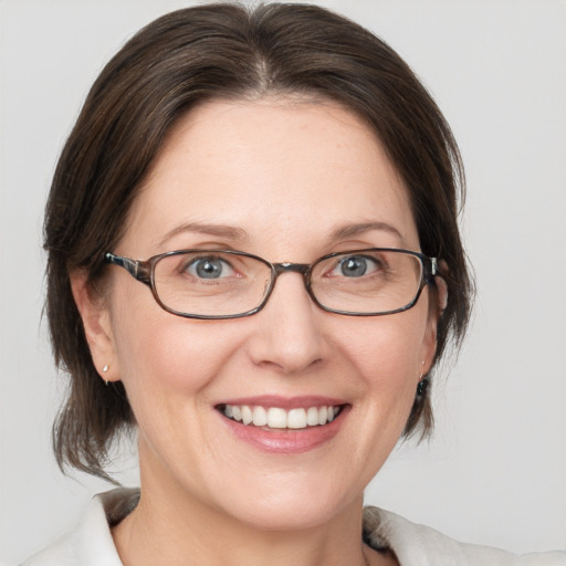 Joyful white adult female with medium  brown hair and grey eyes