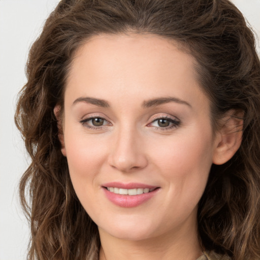 Joyful white young-adult female with long  brown hair and green eyes