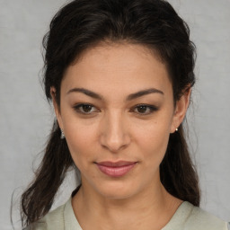 Joyful latino young-adult female with medium  brown hair and brown eyes