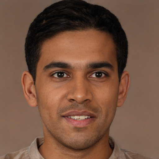 Joyful latino young-adult male with short  brown hair and brown eyes