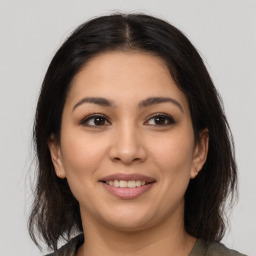 Joyful latino young-adult female with medium  brown hair and brown eyes