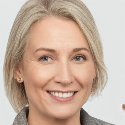 Joyful white adult female with medium  brown hair and blue eyes