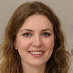 Joyful white young-adult female with long  brown hair and green eyes