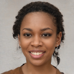 Joyful black young-adult female with long  brown hair and brown eyes