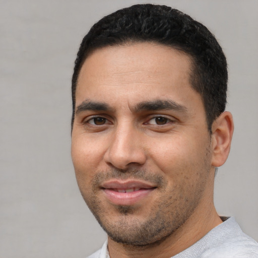 Joyful white young-adult male with short  black hair and brown eyes