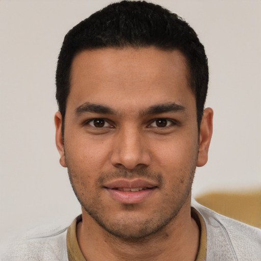 Joyful white young-adult male with short  black hair and brown eyes