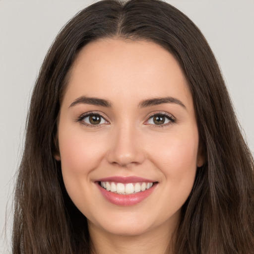 Joyful white young-adult female with long  brown hair and brown eyes