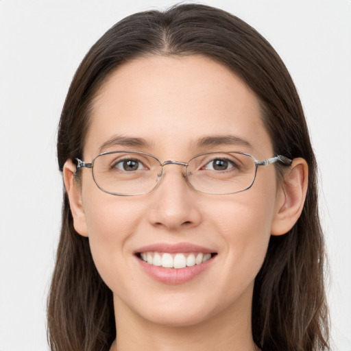 Joyful white young-adult female with long  brown hair and grey eyes