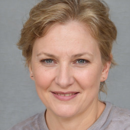 Joyful white adult female with medium  brown hair and blue eyes