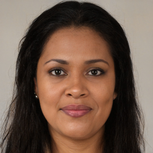 Joyful black young-adult female with long  brown hair and brown eyes