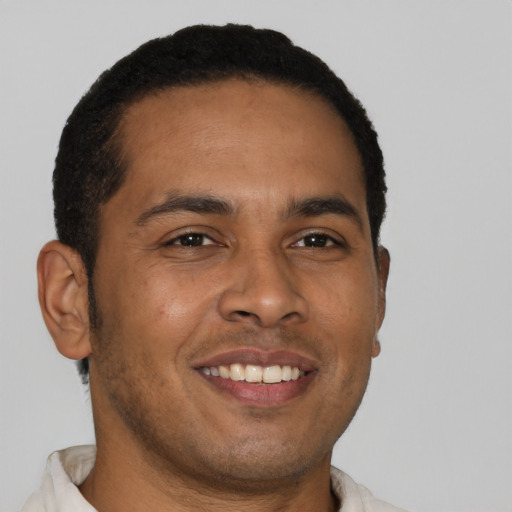 Joyful latino young-adult male with short  brown hair and brown eyes