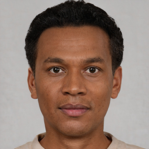 Joyful black young-adult male with short  black hair and brown eyes