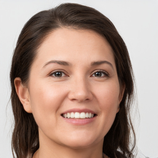 Joyful white young-adult female with medium  brown hair and grey eyes