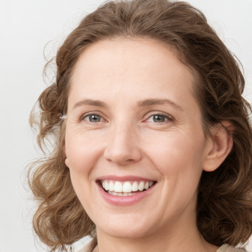 Joyful white young-adult female with medium  brown hair and green eyes