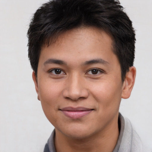 Joyful asian young-adult male with short  brown hair and brown eyes