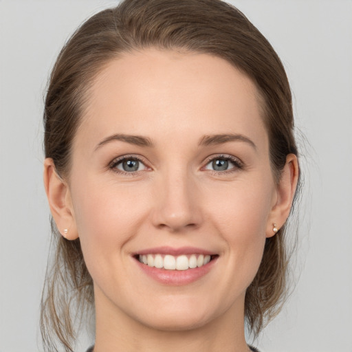 Joyful white young-adult female with medium  brown hair and grey eyes