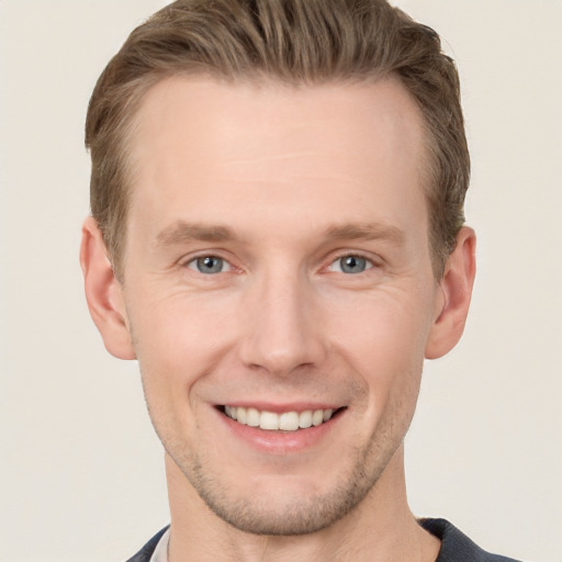 Joyful white young-adult male with short  brown hair and grey eyes