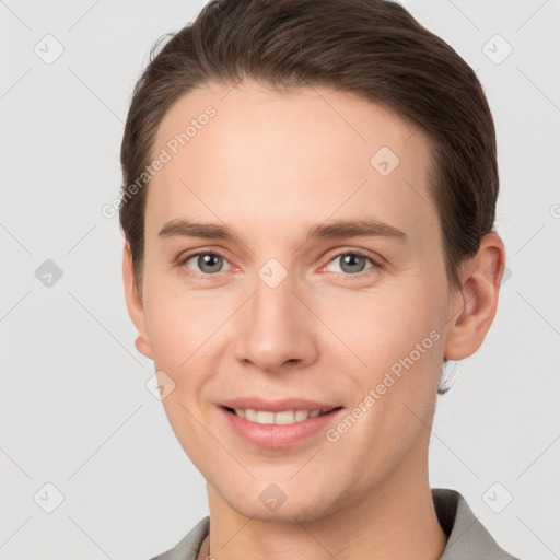 Joyful white young-adult male with short  brown hair and grey eyes