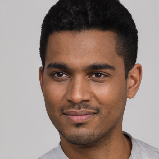 Joyful black young-adult male with short  black hair and brown eyes